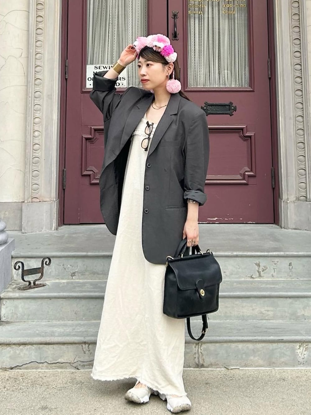 グレー系のテーラードジャケット、ベージュ系のワンピース/ドレス、ホワイト系のサンダルを着用したレディースの夏コーディネートの2枚目の写真