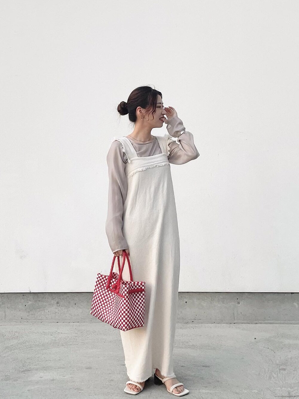 レッド系のハンドバッグ、ベージュ系のワンピース/ドレス、グレー系のTシャツ/カットソーを着用したレディースの夏コーディネートの2枚目の写真