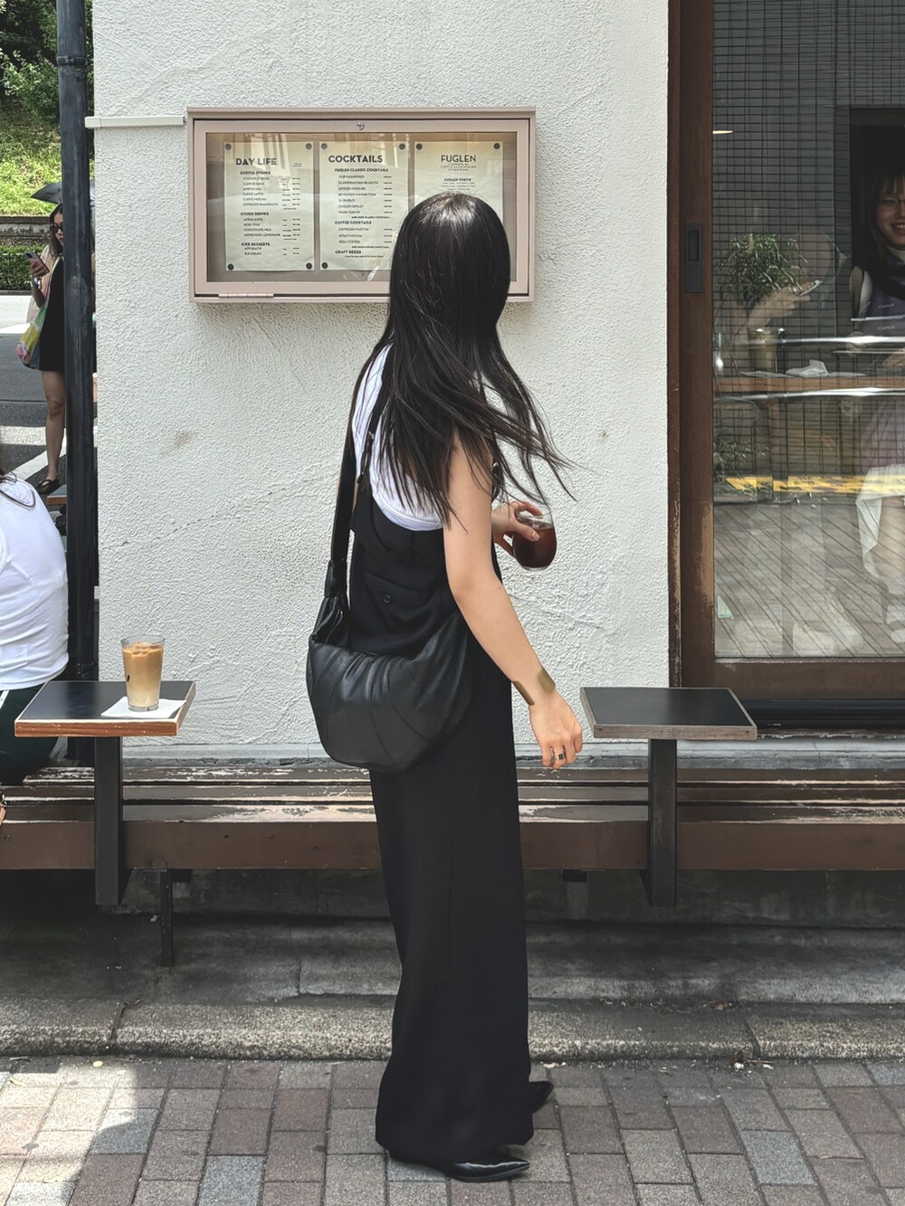 ブラック系のショルダーバッグ、ブラック系のオールインワン・サロペット、ホワイト系のタンクトップを着用したレディースの夏コーディネートの2枚目の写真