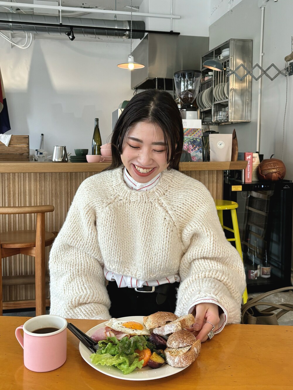 ホワイト系のニット/セーター、ホワイト系のシャツ/ブラウス、ブラック系のその他パンツを着用したレディースの春コーディネートの2枚目の写真