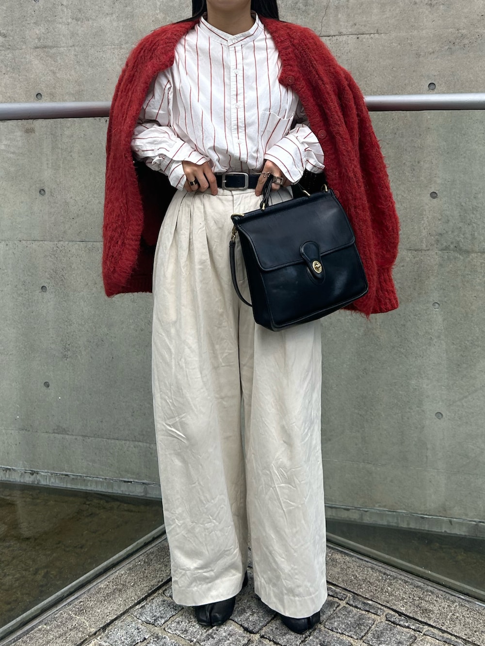 レッド系のカーディガン/ボレロ、ホワイト系のシャツ/ブラウス、ベージュ系のチノパンツを着用したレディースの春コーディネートの2枚目の写真