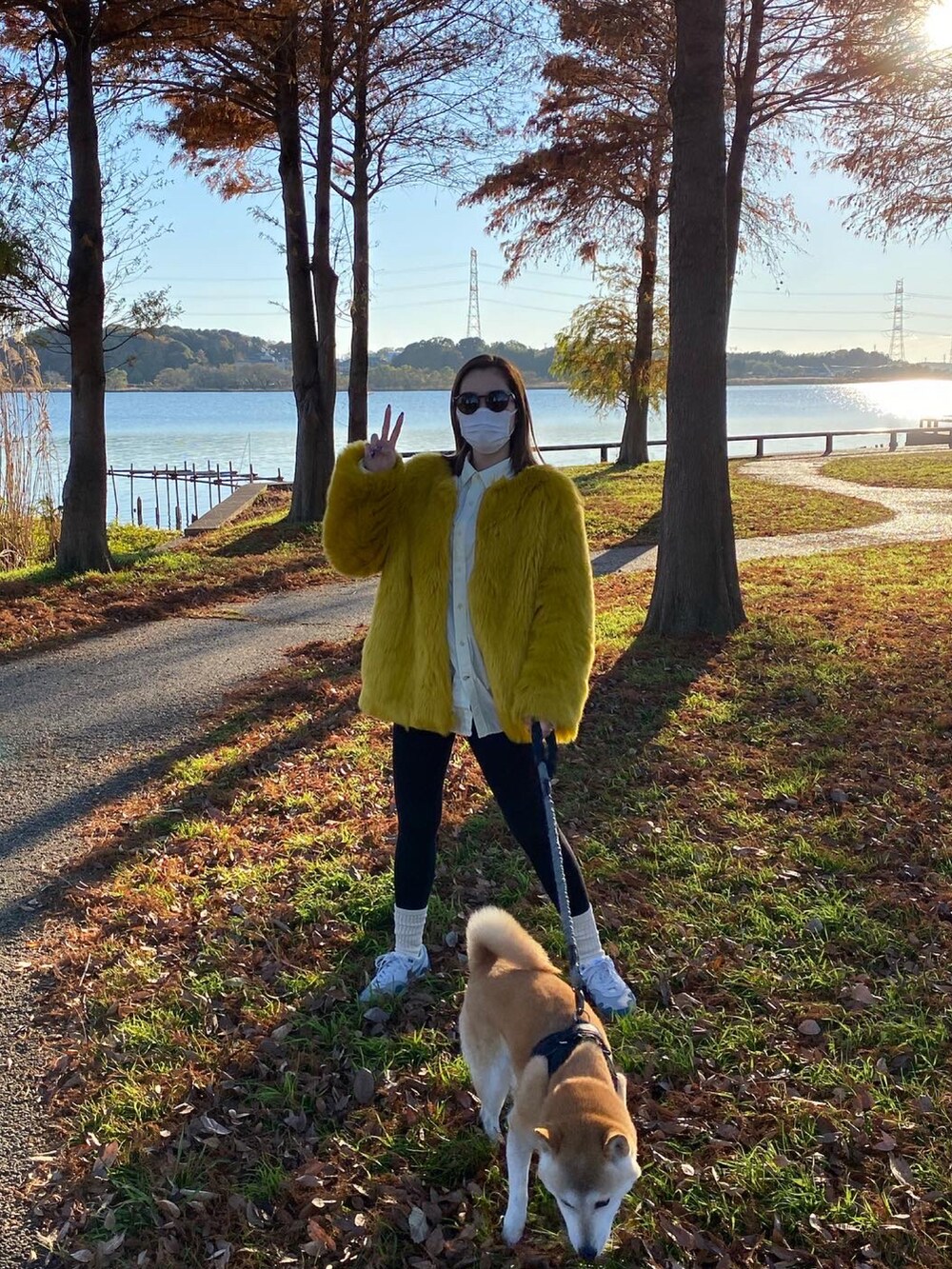 ホワイト系のスニーカー、ブラウン系のサングラスを着用したレディースの冬コーディネートの2枚目の写真