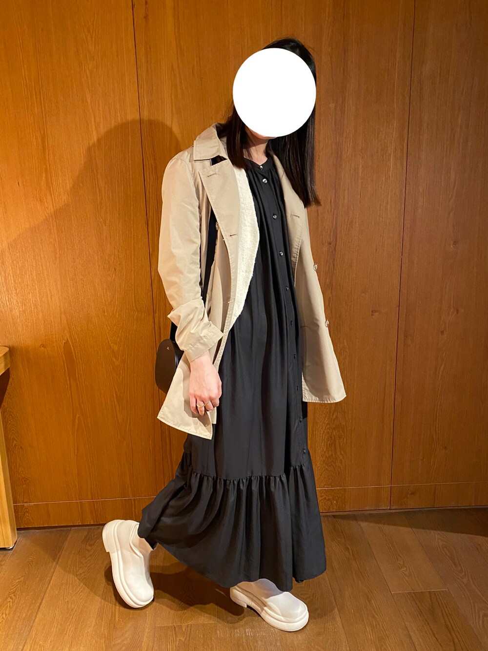 ブラック系のワンピース、ホワイト系のブーツ、ブラック系のショルダーバッグを着用したレディースの冬コーディネートの3枚目の写真