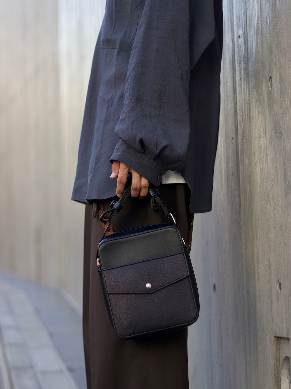 ブルー系のシャツ/ブラウス、ホワイト系のタンクトップ、ブラウン系のスラックスを着用したメンズの秋コーディネートの3枚目の写真