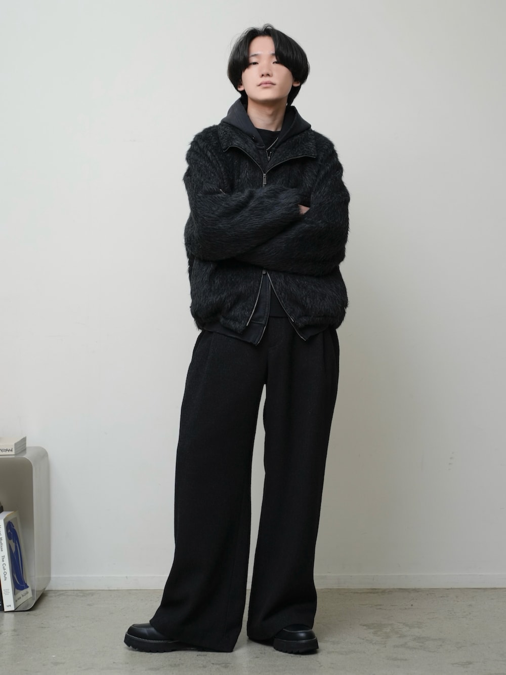 グレー系のブルゾン、ブラック系のパーカー、ブラック系のタンクトップを着用したメンズの秋コーディネートの2枚目の写真