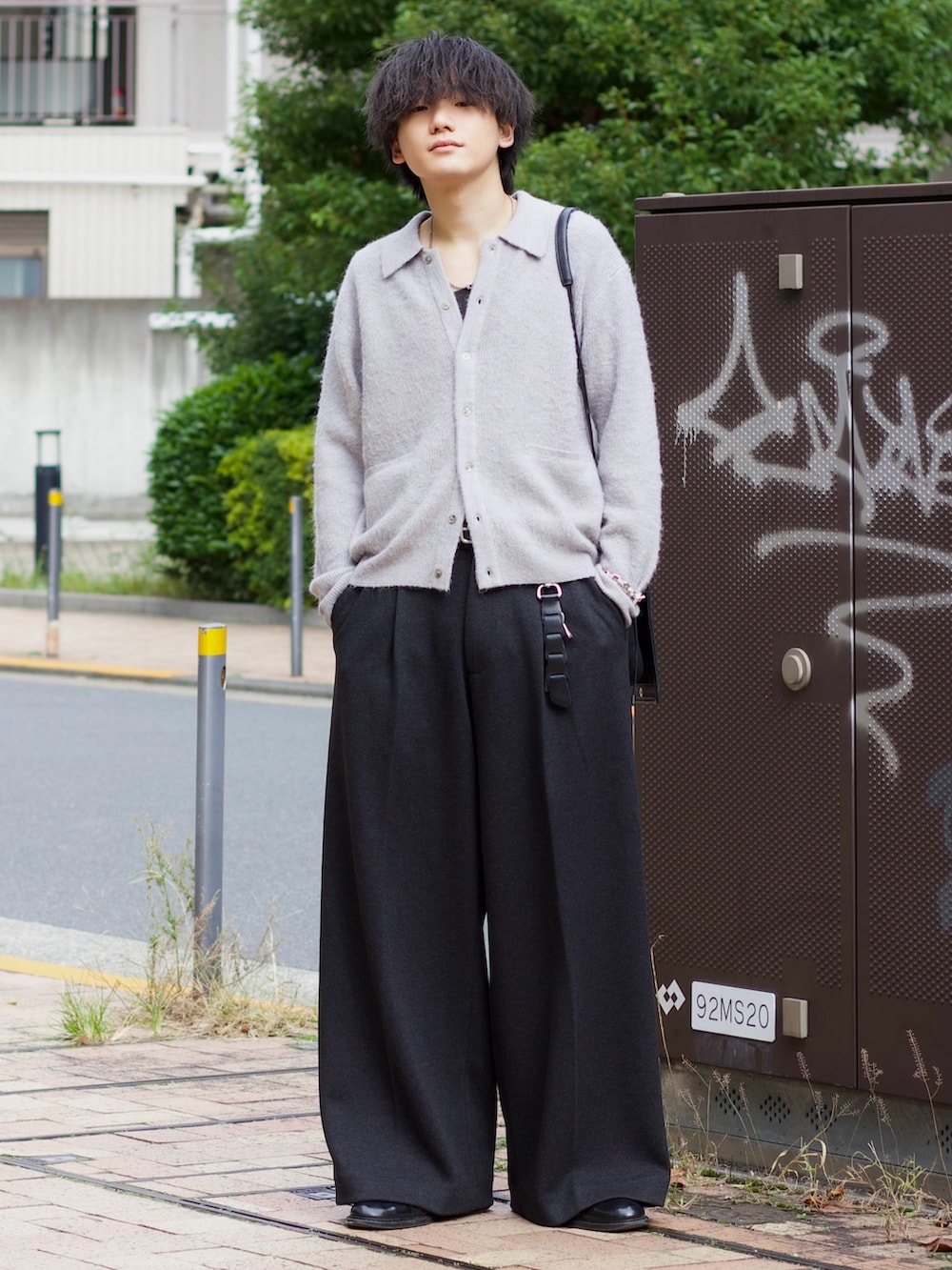 グレー系のニット/セーター、ブラック系のタンクトップ、グレー系のスラックスを着用したメンズの秋コーディネートの2枚目の写真