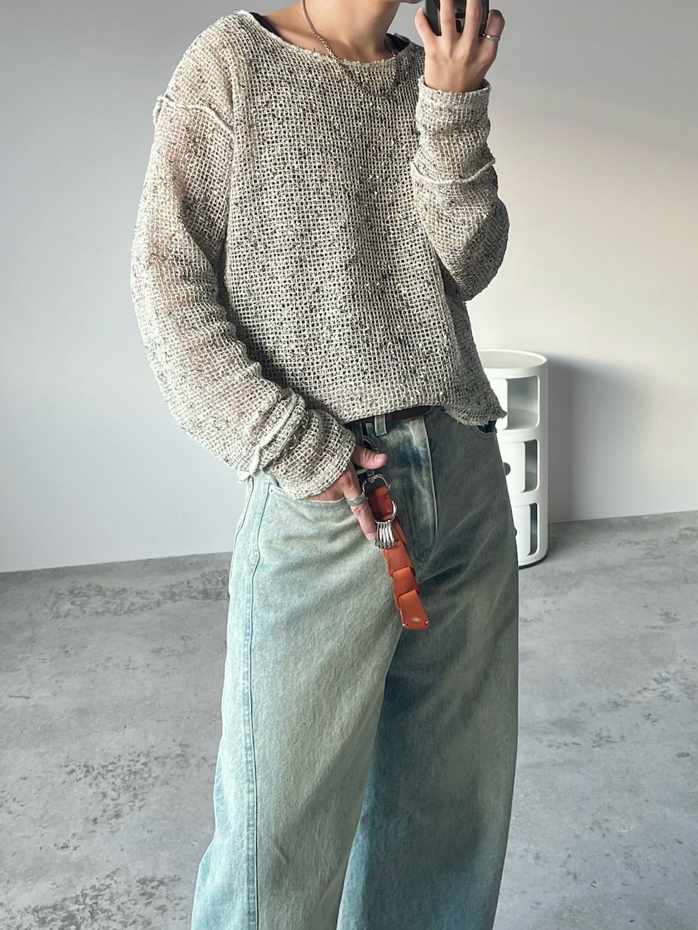 ブラック系のタンクトップ、ベージュ系のその他トップス、ブルー系のデニムパンツを着用したメンズの秋コーディネートの2枚目の写真