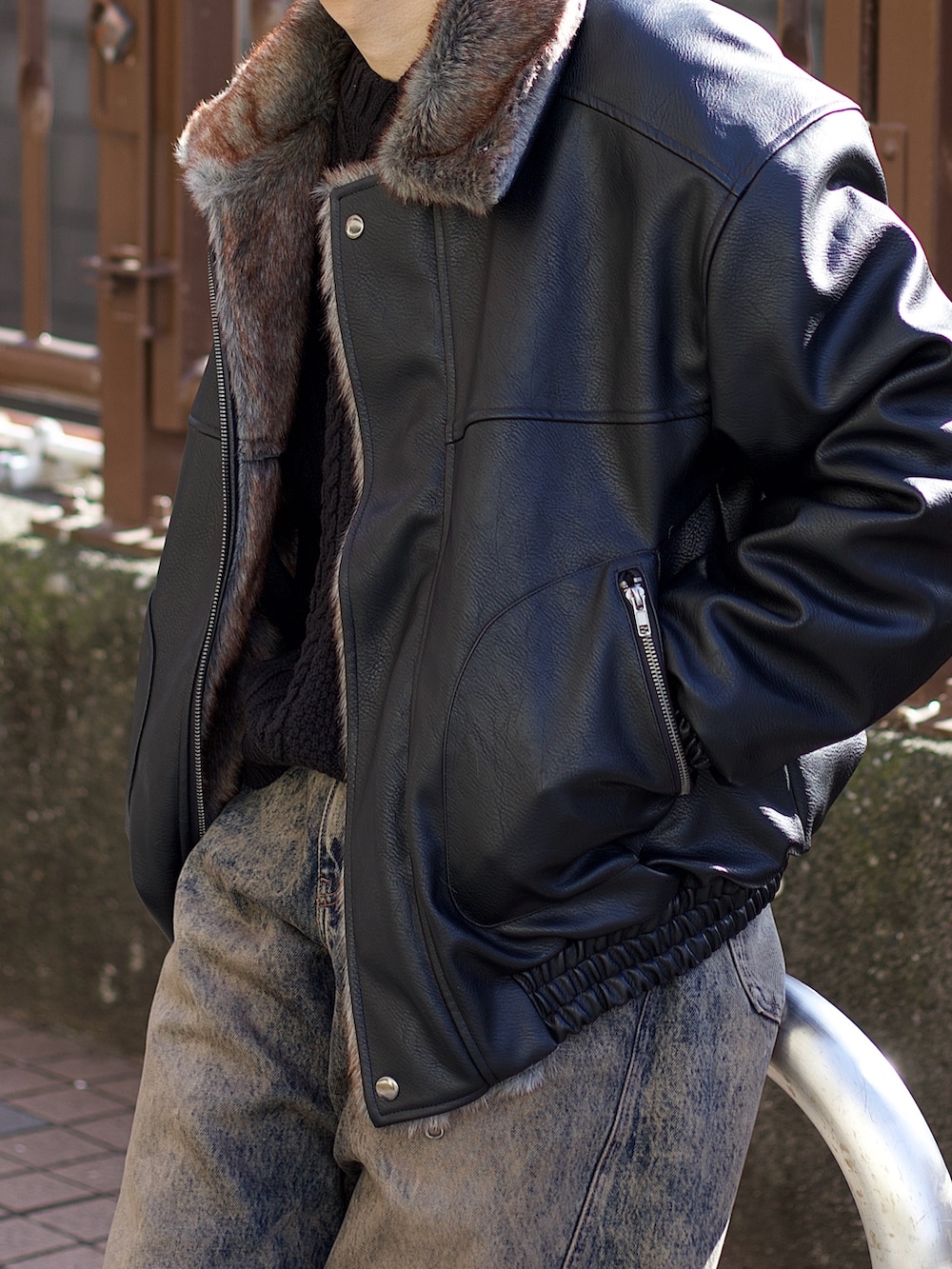 ブラック系のその他アウター、ブラック系のニット/セーター、ブルー系のデニムパンツを着用したメンズの冬コーディネートの3枚目の写真