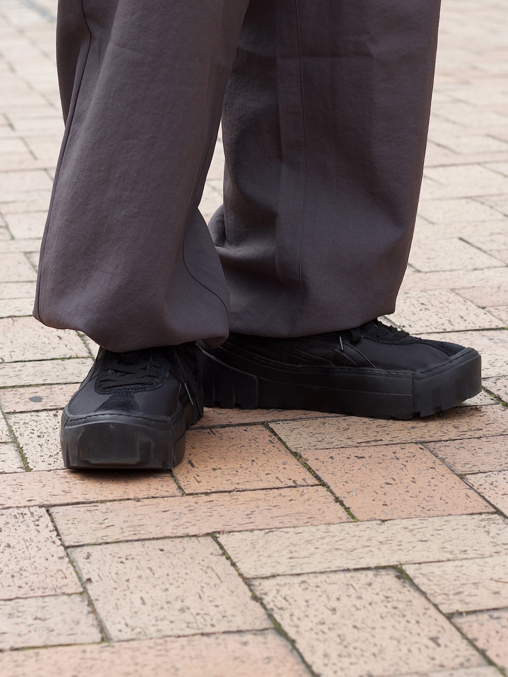 ブラック系のベスト、ブラック系のTシャツ/カットソー、グレー系のカーゴパンツを着用したメンズの春コーディネートの4枚目の写真