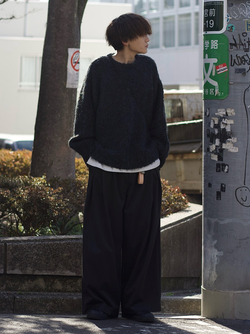 ブルー系のニット/セーター、ホワイト系のタンクトップ、グレー系のスラックスを着用したメンズの冬コーディネートの2枚目の写真