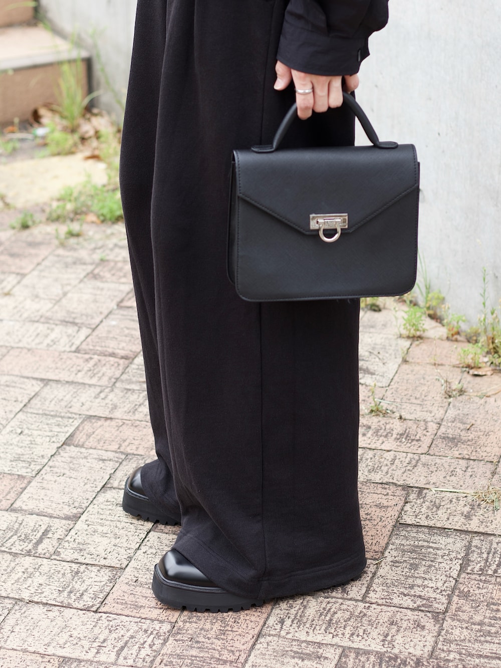 ブラック系のテーラードジャケット、ブラック系のタンクトップ、ブラック系のスウェットパンツを着用したメンズの春コーディネートの4枚目の写真