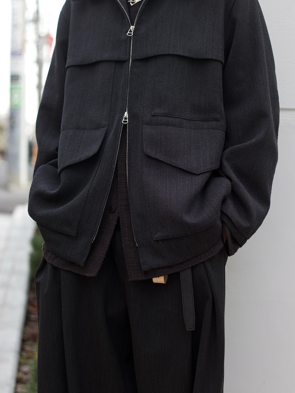 グレー系のブルゾン、グレー系のシャツ/ブラウス、ブラック系のニット/セーターを着用したメンズの冬コーディネートの3枚目の写真