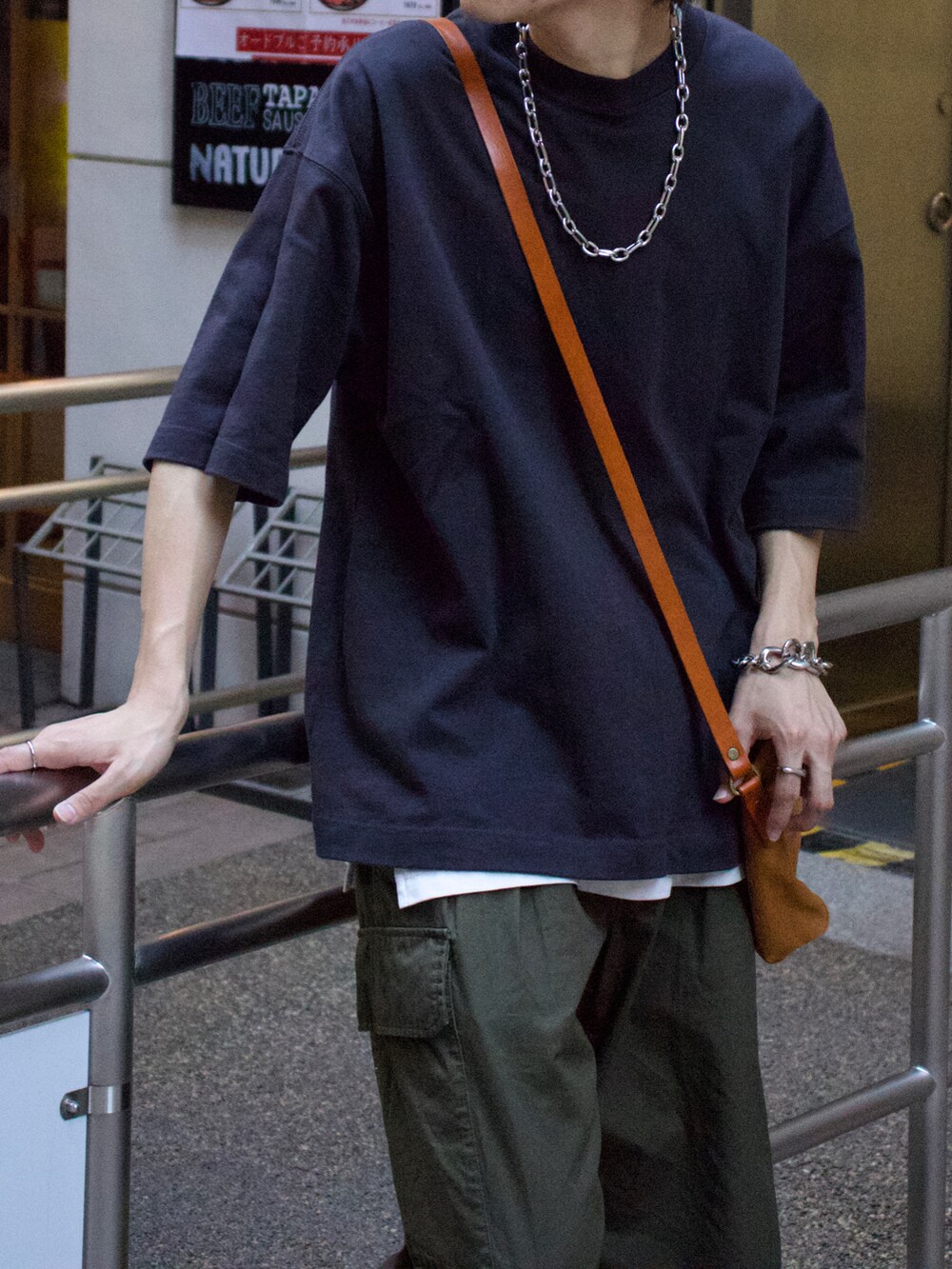 グレー系のTシャツ/カットソー、ホワイト系のタンクトップ、グリーン系のカーゴパンツを着用したメンズの夏コーディネートの3枚目の写真