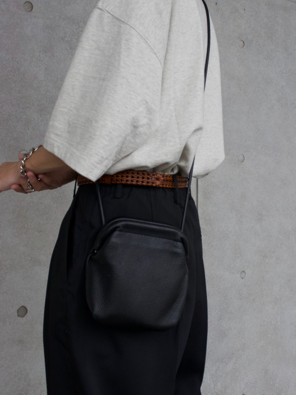 ベージュ系のTシャツ/カットソー、ホワイト系のタンクトップ、ブラック系のスラックスを着用したメンズの夏コーディネートの4枚目の写真