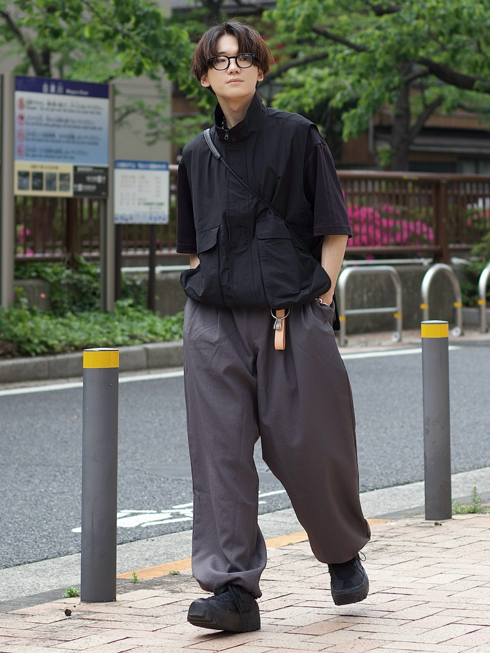 ブラック系のベスト、ブラック系のTシャツ/カットソー、グレー系のカーゴパンツを着用したメンズの春コーディネートの2枚目の写真