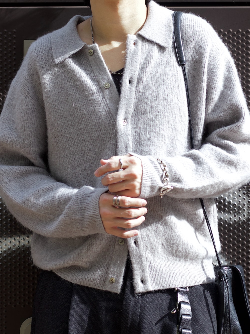 グレー系のニット/セーター、ブラック系のタンクトップ、グレー系のスラックスを着用したメンズの秋コーディネートの3枚目の写真