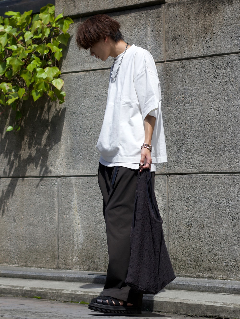 ホワイト系のTシャツ/カットソー、ホワイト系のタンクトップ、グレー系のスラックスを着用したメンズの夏コーディネートの2枚目の写真