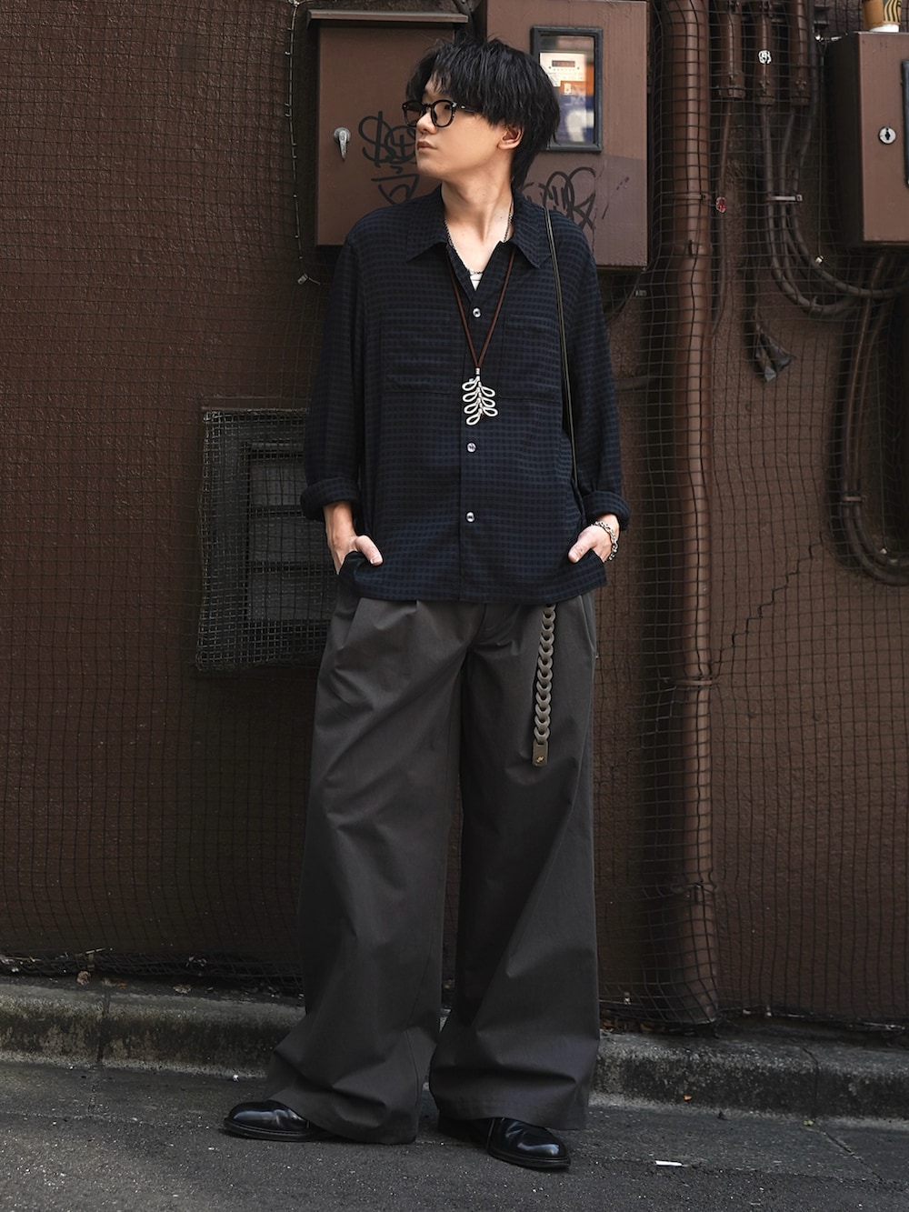 グレー系のタンクトップ、ブラック系のドレスシューズ、ブラウン系のショルダーバッグを着用したメンズの春コーディネートの2枚目の写真