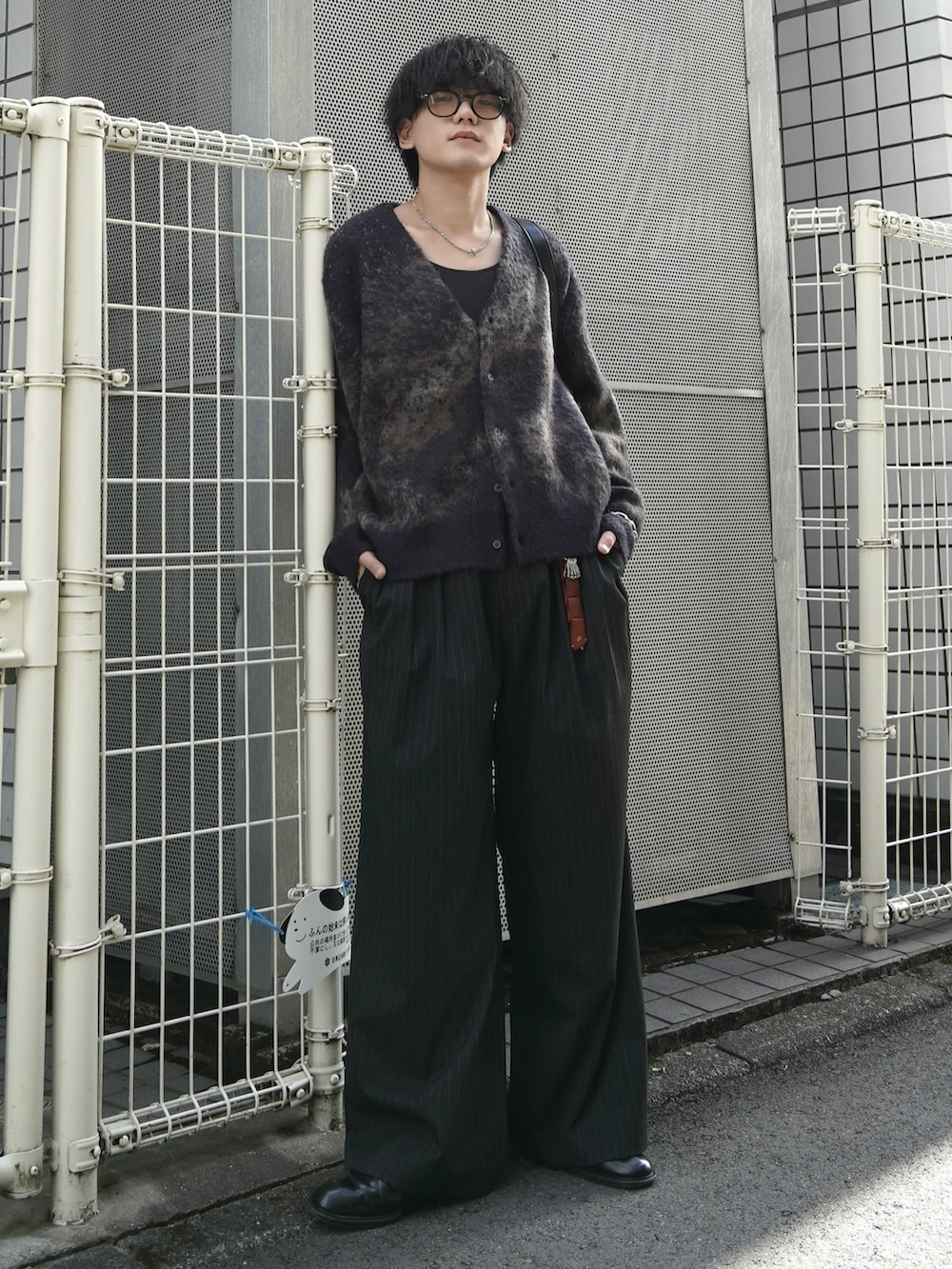 ブラック系のタンクトップ、ブラウン系のカーディガン/ボレロ、グレー系のスラックスを着用したメンズの秋コーディネートの2枚目の写真