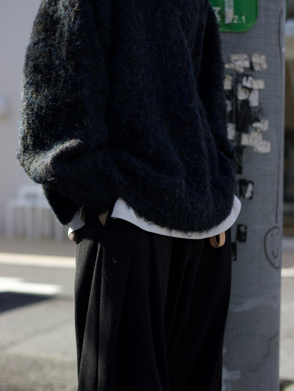 ブルー系のニット/セーター、ホワイト系のタンクトップ、グレー系のスラックスを着用したメンズの冬コーディネートの3枚目の写真