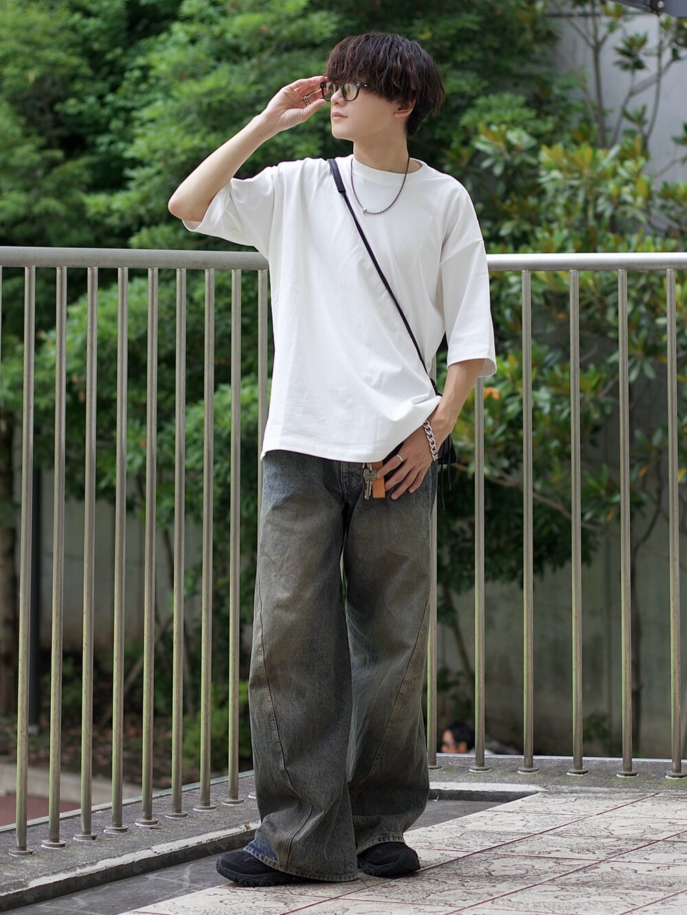 ホワイト系のTシャツ/カットソー、ブルー系のデニムパンツ、ブラック系のスニーカーを着用したメンズの夏コーディネートの2枚目の写真