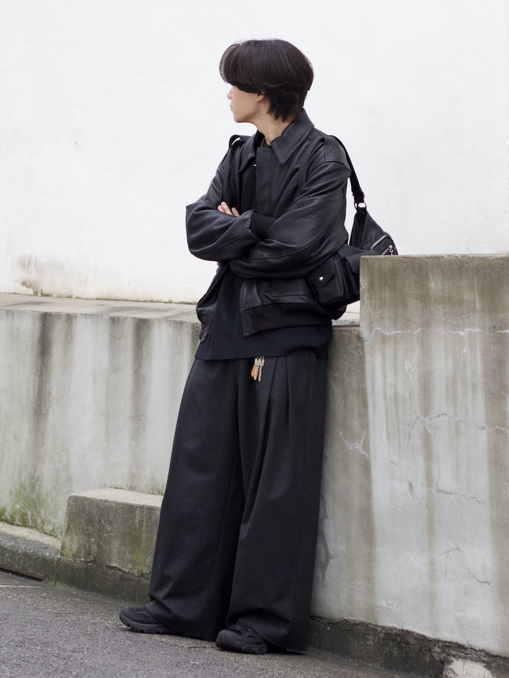 ブラック系のブルゾン、グレー系のニット/セーター、グレー系のスラックスを着用したメンズの秋コーディネートの2枚目の写真