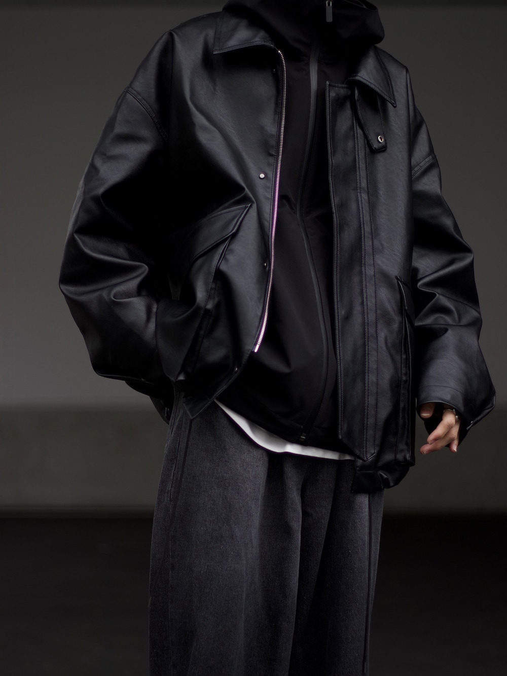 ブラック系のブルゾン、ブラック系のマウンテンパーカー、ホワイト系のタンクトップを着用したメンズの秋コーディネートの3枚目の写真