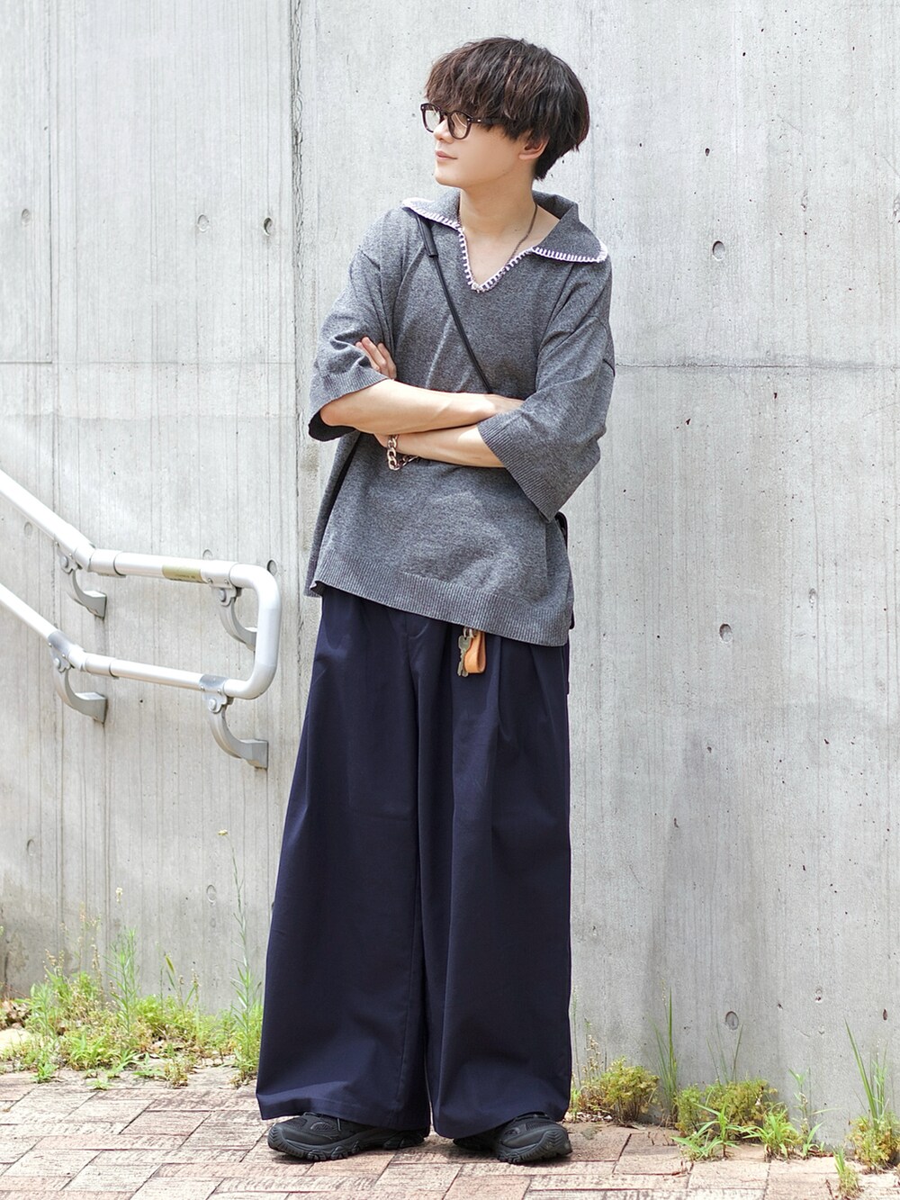 ブラック系のポロシャツ、ブルー系のスラックス、ブラック系のスニーカーを着用したメンズの夏コーディネートの2枚目の写真