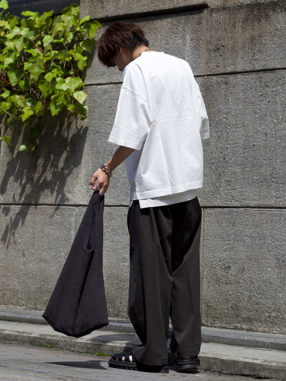 ホワイト系のTシャツ/カットソー、ホワイト系のタンクトップ、グレー系のスラックスを着用したメンズの夏コーディネートの3枚目の写真