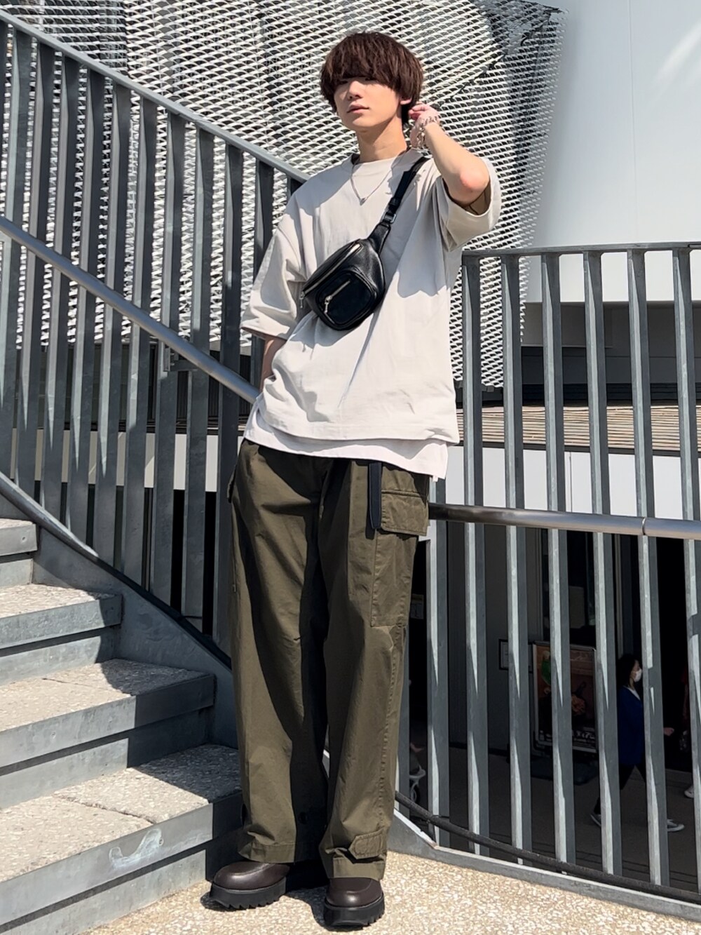 グレー系のTシャツ/カットソー、ホワイト系のタンクトップ、グリーン系のカーゴパンツを着用したメンズの春コーディネートの2枚目の写真