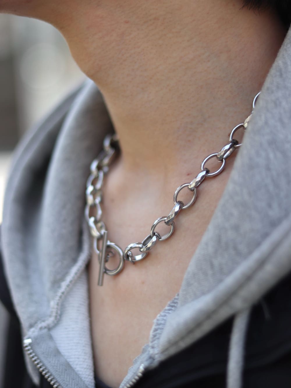 ブラック系のブルゾン、グレー系のパーカー、ブラック系のタンクトップを着用したメンズの春コーディネートの4枚目の写真