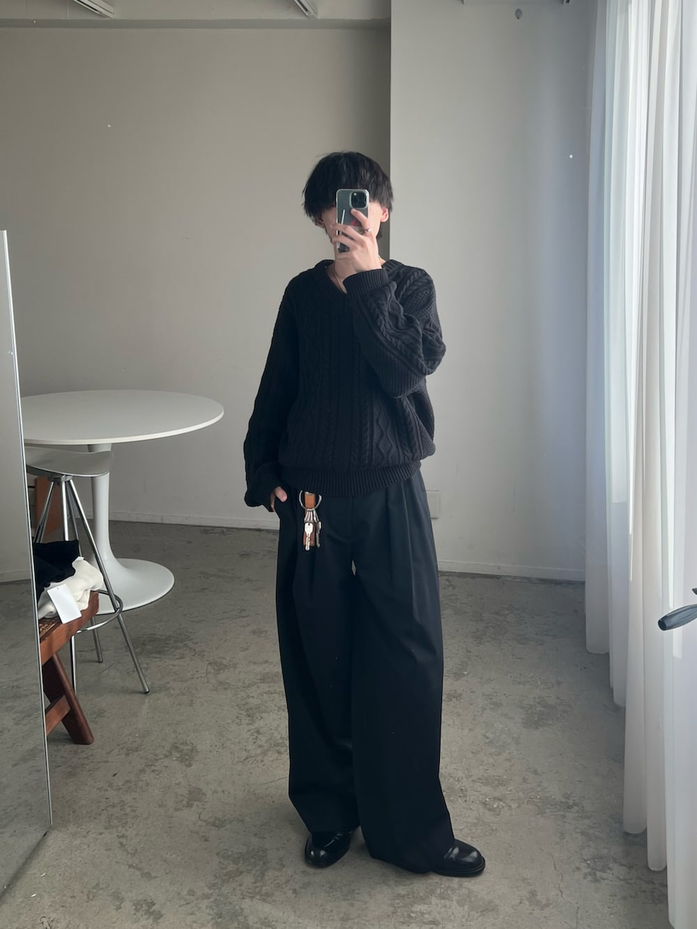 ブラック系のニット/セーター、ブラック系のスラックス、ブラック系のドレスシューズを着用したメンズの秋コーディネートの2枚目の写真