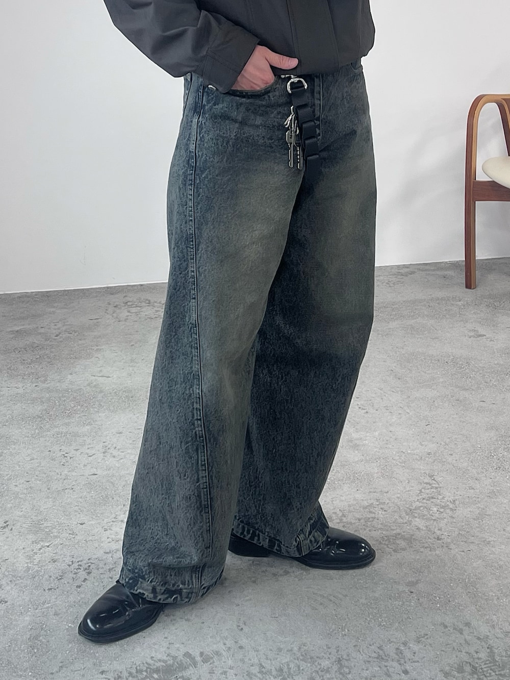 ブラウン系のブルゾン、ブルー系のデニムパンツ、ブラック系のドレスシューズを着用したメンズの春コーディネートの3枚目の写真