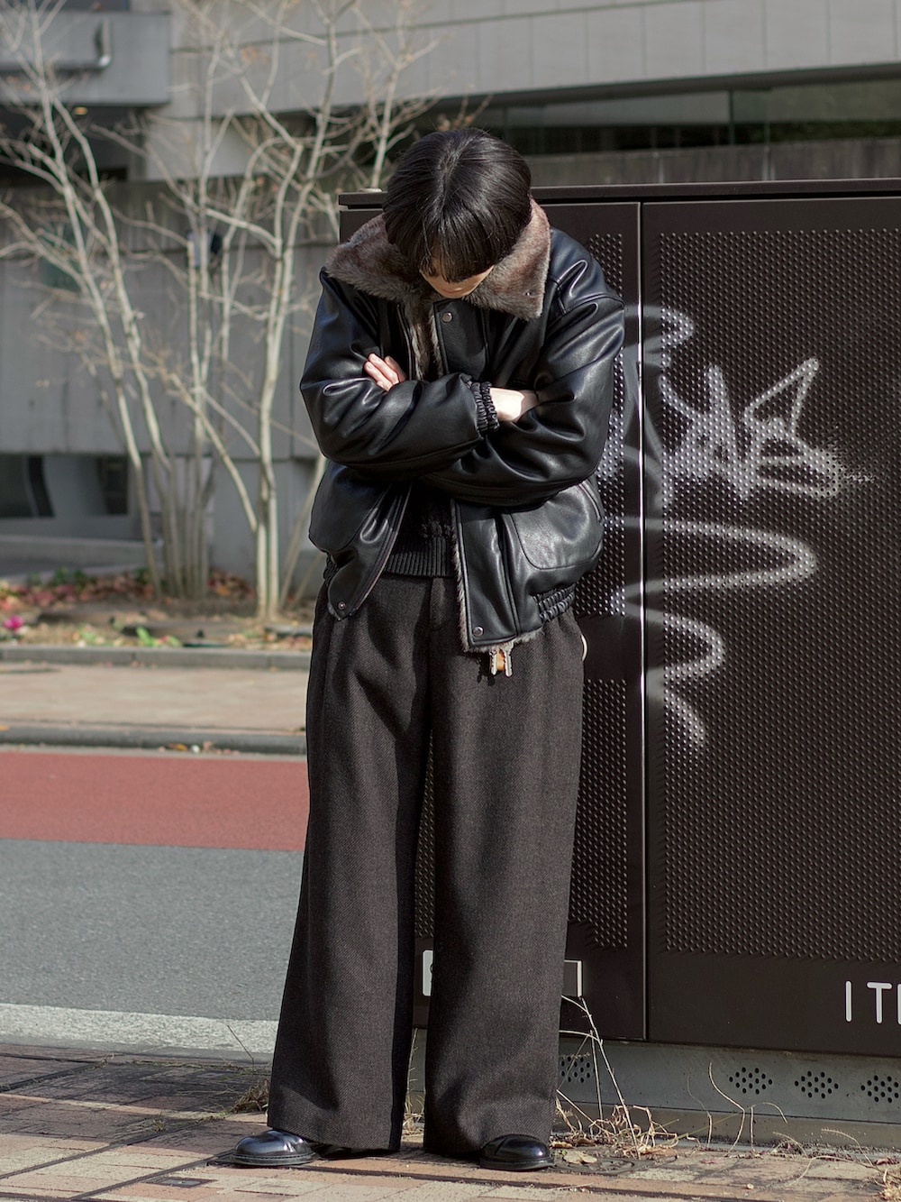 ブラック系のその他アウター、ブラック系のニット/セーター、ブラウン系のスラックスを着用したメンズの冬コーディネートの2枚目の写真