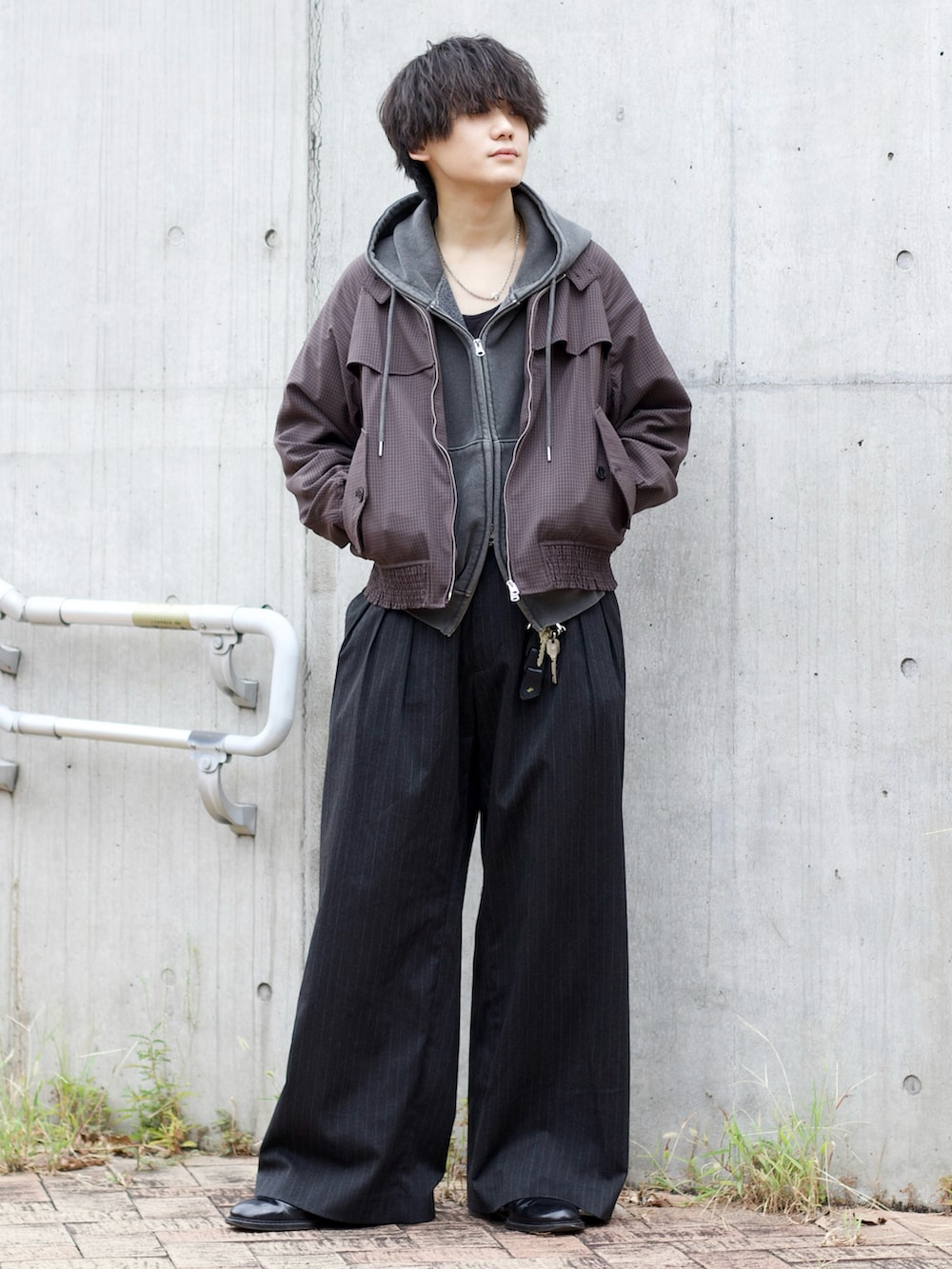 グレー系のパーカー、ブラック系のタンクトップ、ブラウン系のブルゾンを着用したメンズの秋コーディネートの2枚目の写真
