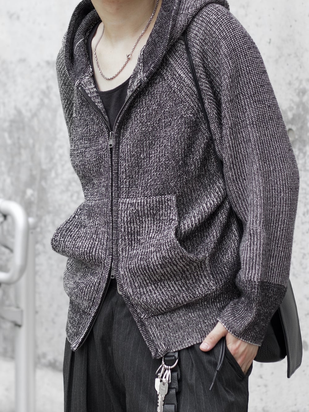 グレー系のニット/セーター、ブラック系のタンクトップ、グレー系のスラックスを着用したメンズの秋コーディネートの3枚目の写真