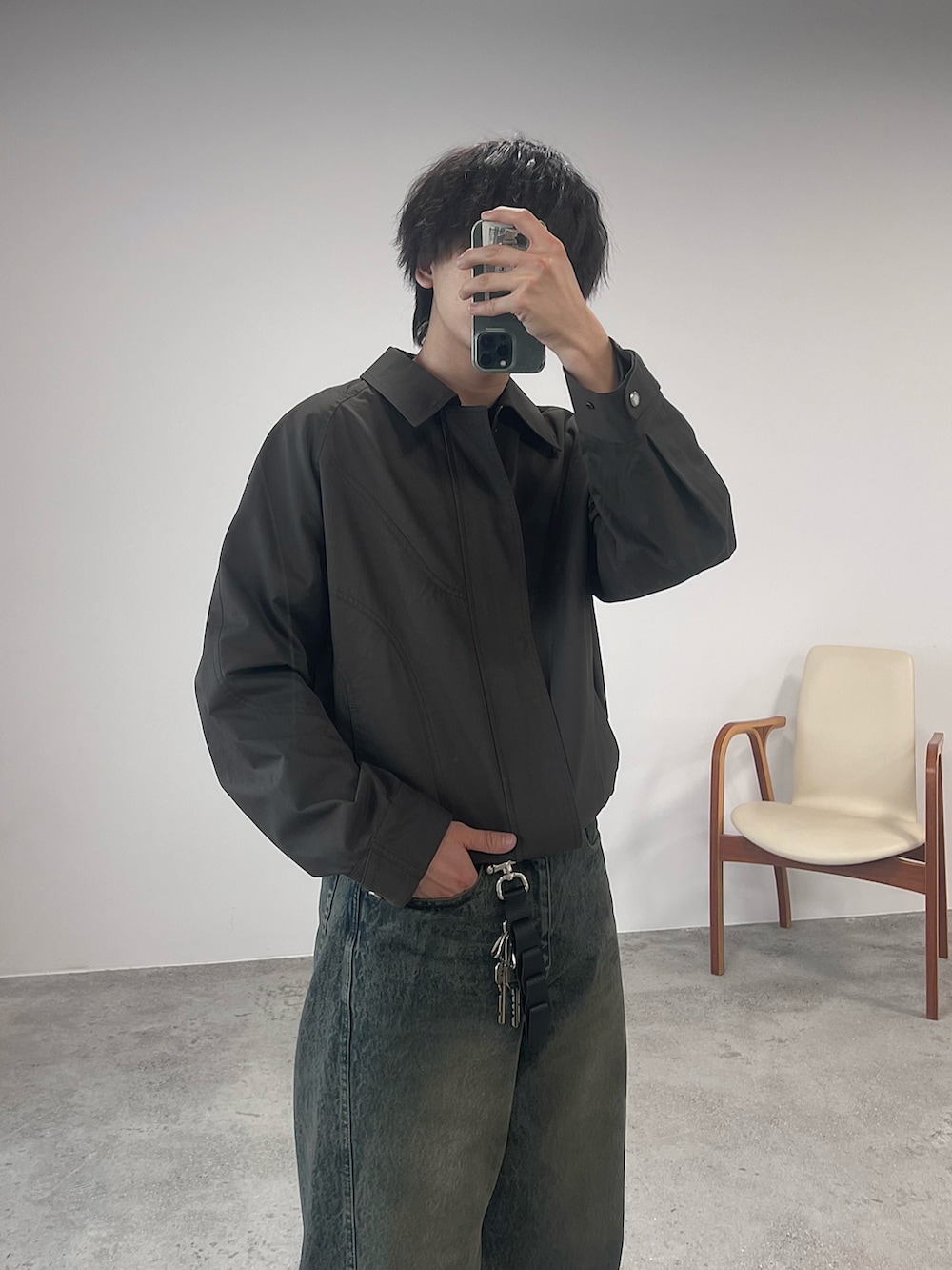 ブラウン系のブルゾン、ブルー系のデニムパンツ、ブラック系のドレスシューズを着用したメンズの春コーディネートの2枚目の写真