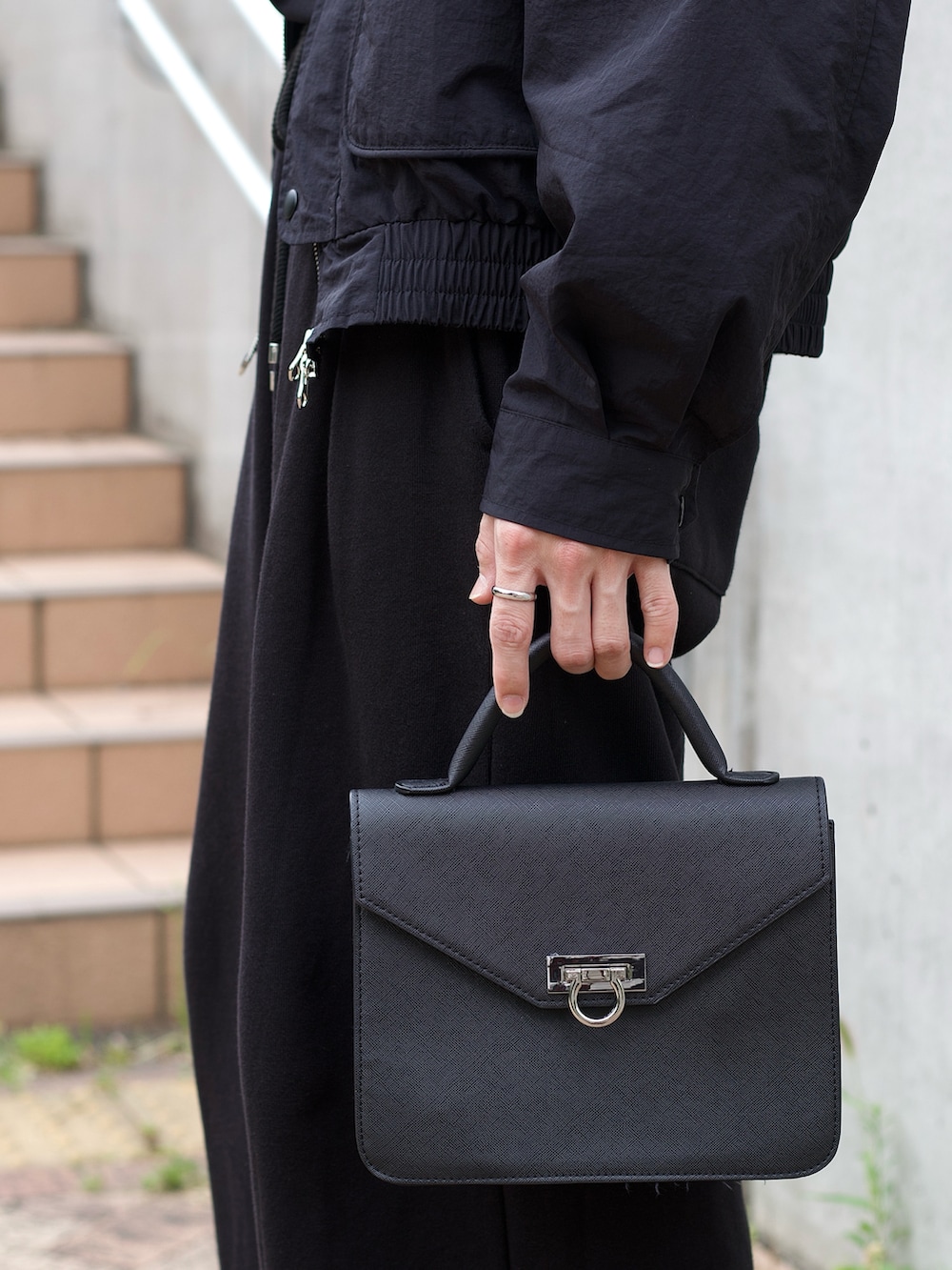 ブラック系のテーラードジャケット、ブラック系のタンクトップ、ブラック系のスウェットパンツを着用したメンズの春コーディネートの3枚目の写真