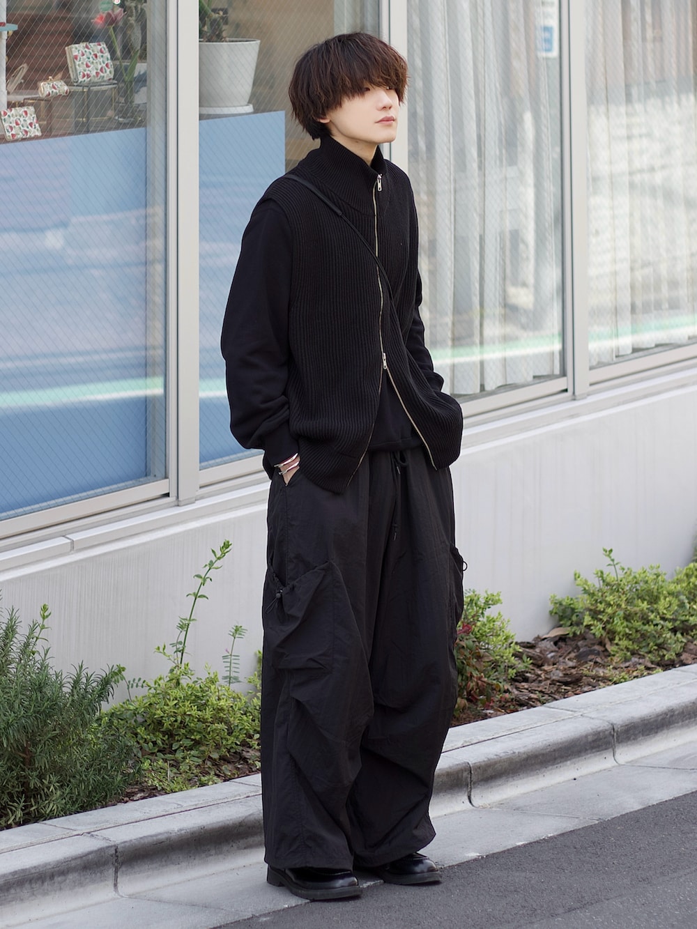 ブラック系のベスト、ブラック系のスウェット、ブラック系のドレスシューズを着用したメンズの春コーディネートの2枚目の写真