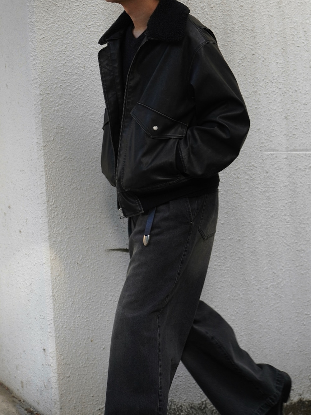 ブラック系のブルゾン、ブラック系のデニムパンツ、ブラック系のドレスシューズを着用したメンズの秋コーディネートの2枚目の写真