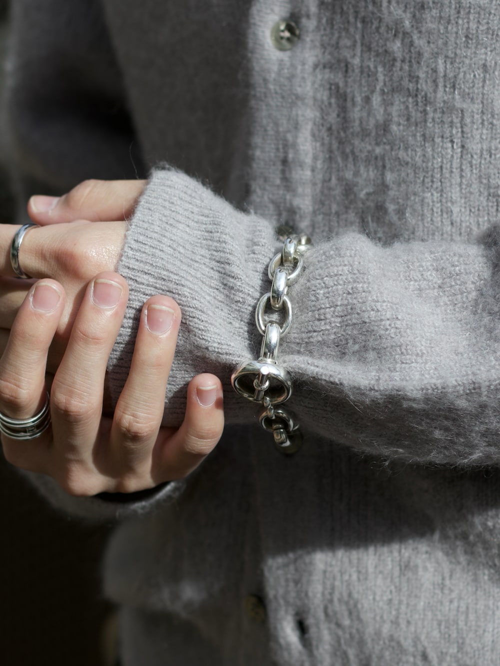 グレー系のニット/セーター、ブラック系のタンクトップ、グレー系のスラックスを着用したメンズの秋コーディネートの5枚目の写真