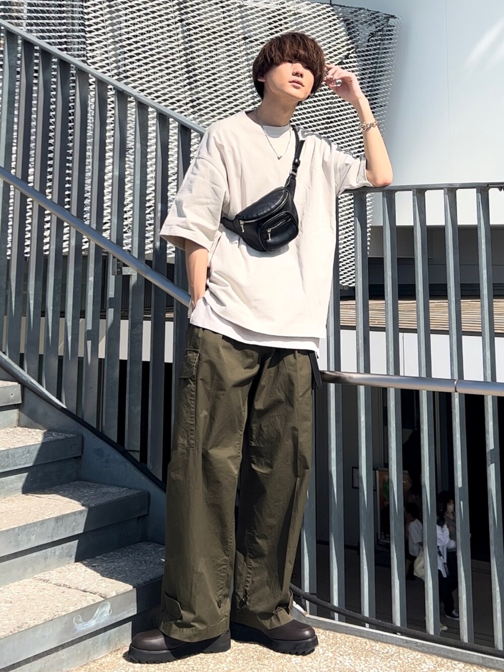 グレー系のTシャツ/カットソー、ホワイト系のタンクトップ、グリーン系のカーゴパンツを着用したメンズの春コーディネートの3枚目の写真