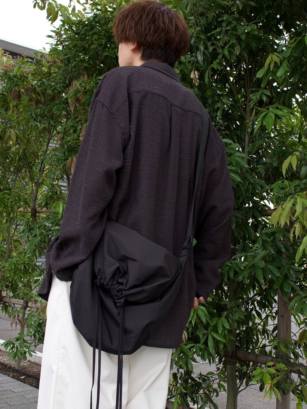 グレー系のシャツ/ブラウス、グレー系のタンクトップ、ホワイト系のスラックスを着用したメンズの夏コーディネートの3枚目の写真