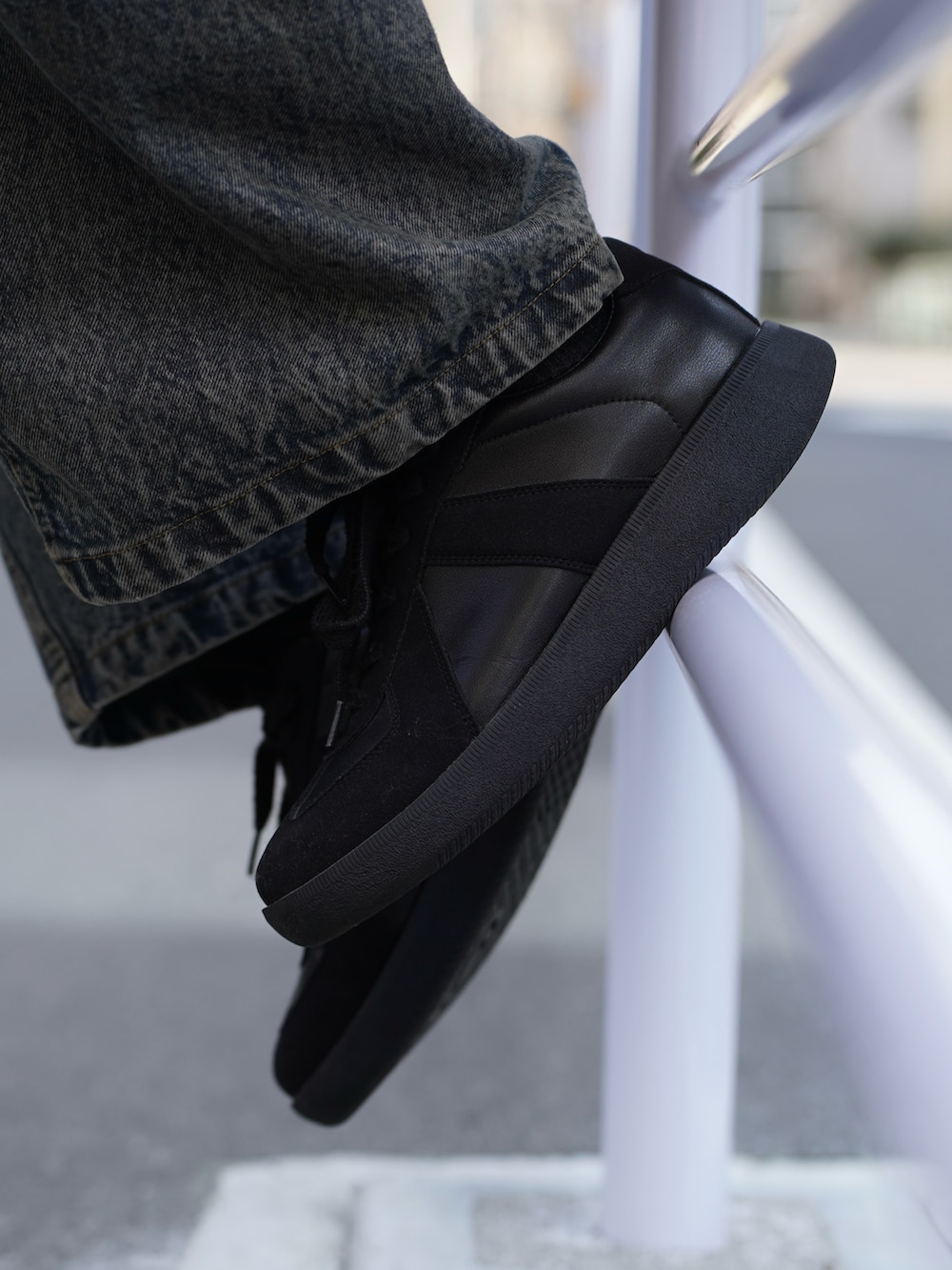 グレー系のブルゾン、ブラック系のタンクトップ、ブルー系のデニムパンツを着用したメンズの春コーディネートの3枚目の写真