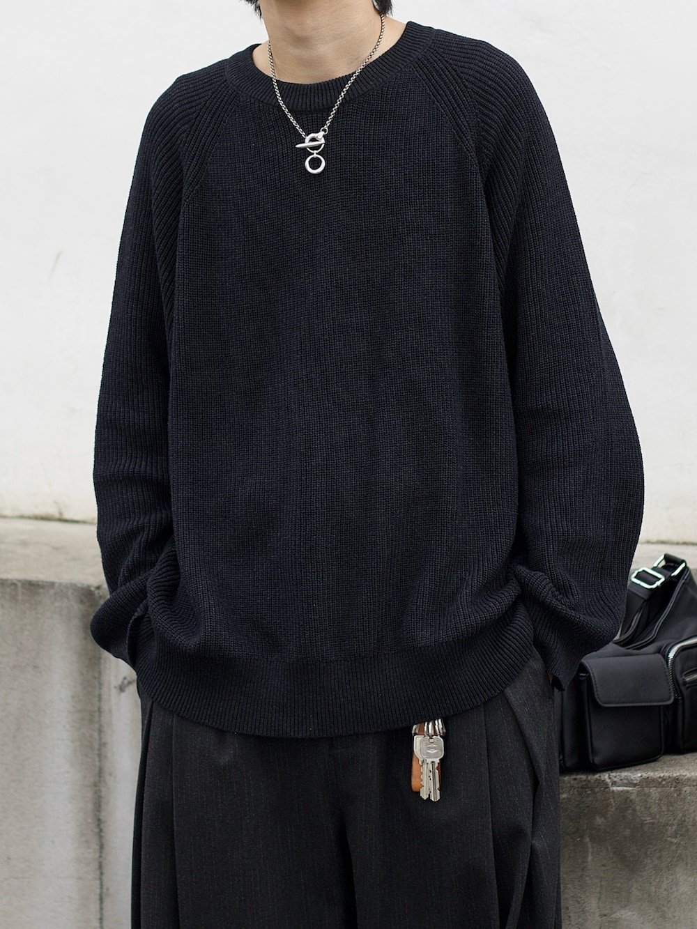 ブラック系のブルゾン、グレー系のニット/セーター、グレー系のスラックスを着用したメンズの秋コーディネートの5枚目の写真