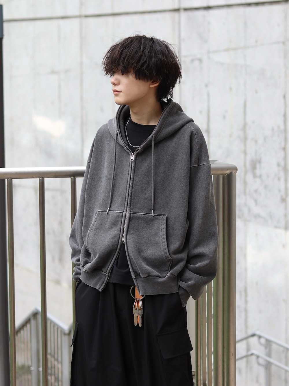 グレー系のパーカー、ブラック系のタンクトップ、ブラック系のカーゴパンツを着用したメンズの秋コーディネートの3枚目の写真