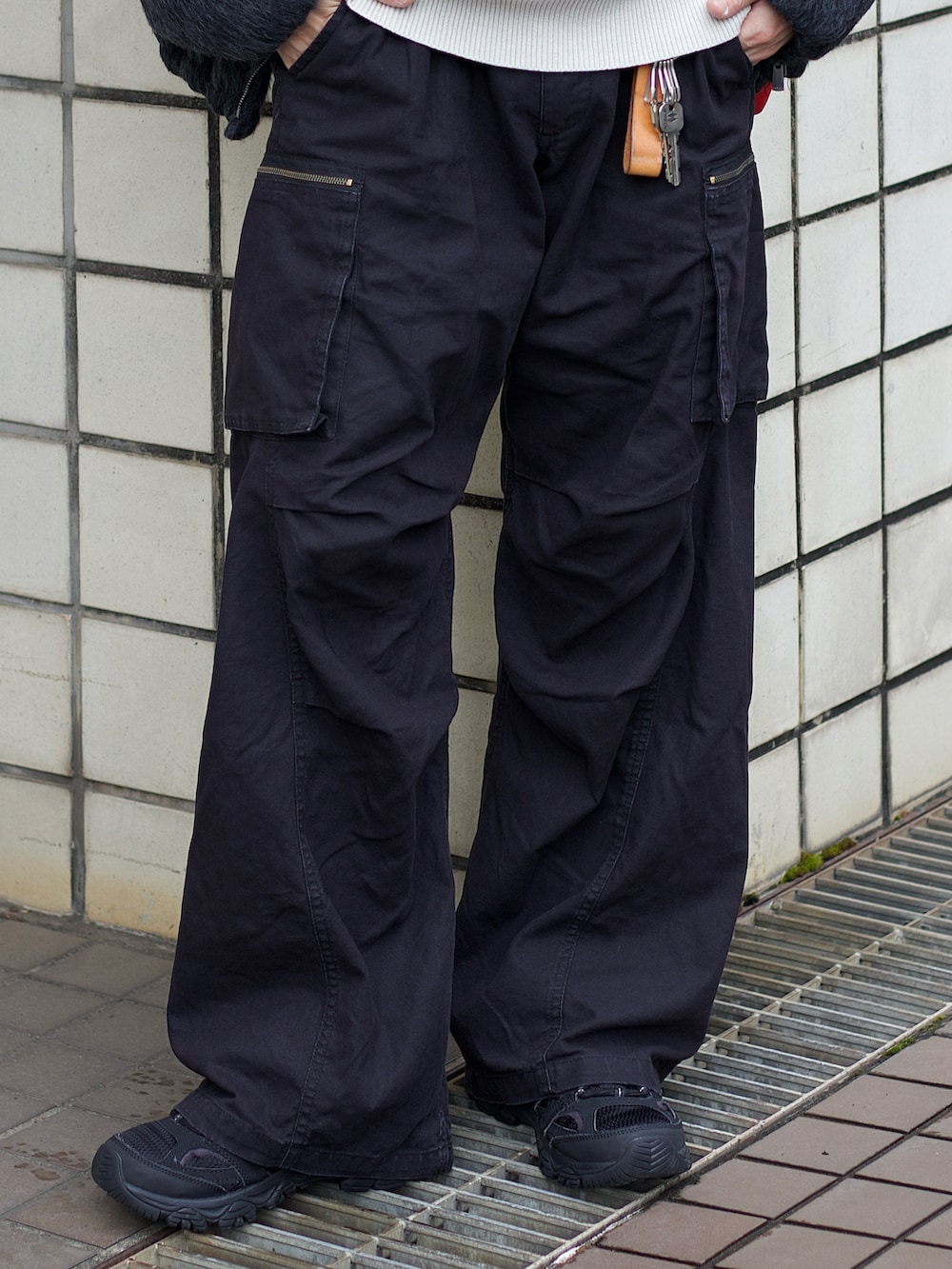 グレー系のブルゾン、ホワイト系のニット/セーター、ブラック系のカーゴパンツを着用したメンズの冬コーディネートの4枚目の写真