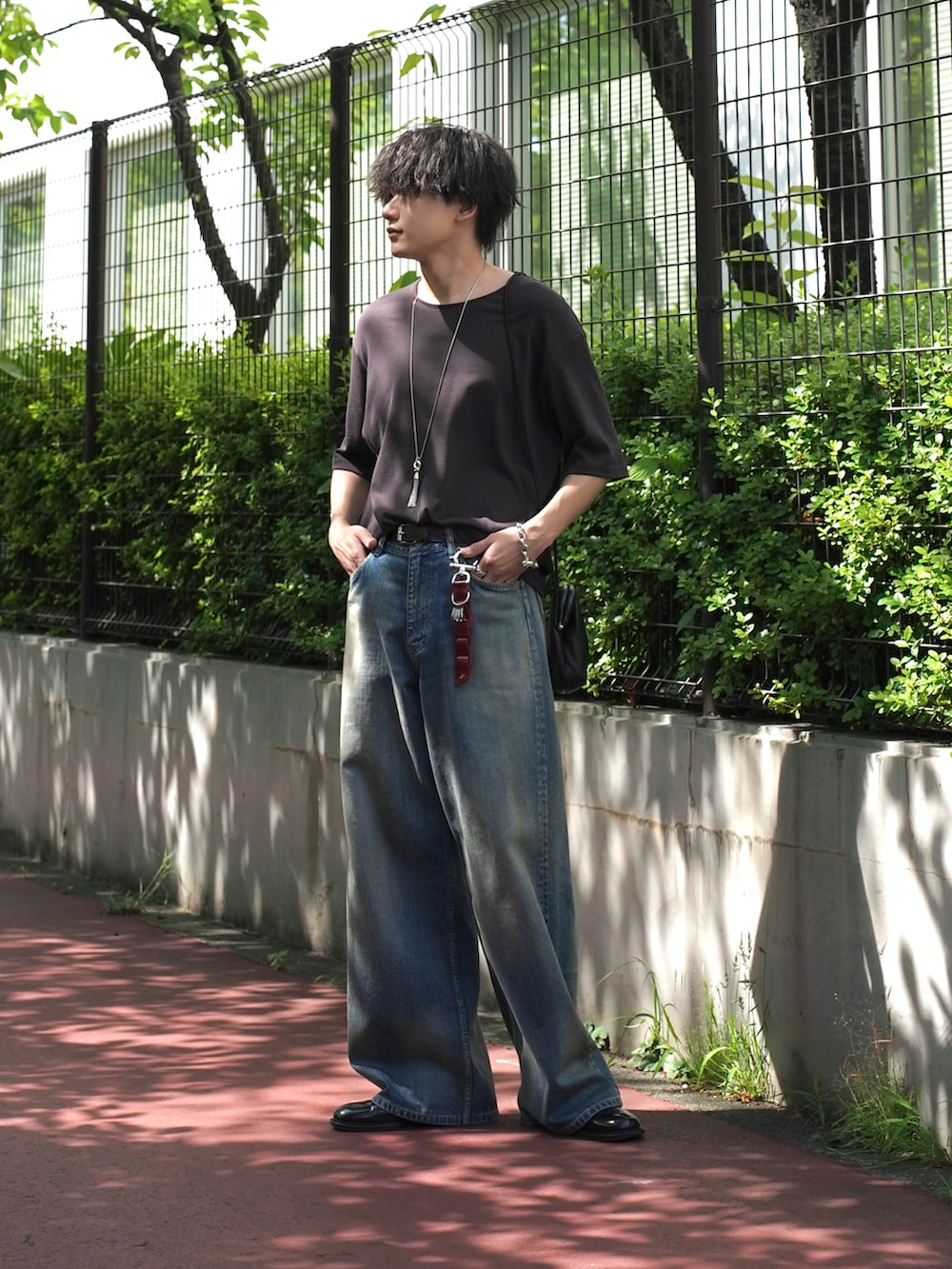 ブラック系のドレスシューズ、ブラック系のショルダーバッグ、ブラウン系のTシャツ/カットソーを着用したメンズの夏コーディネートの2枚目の写真