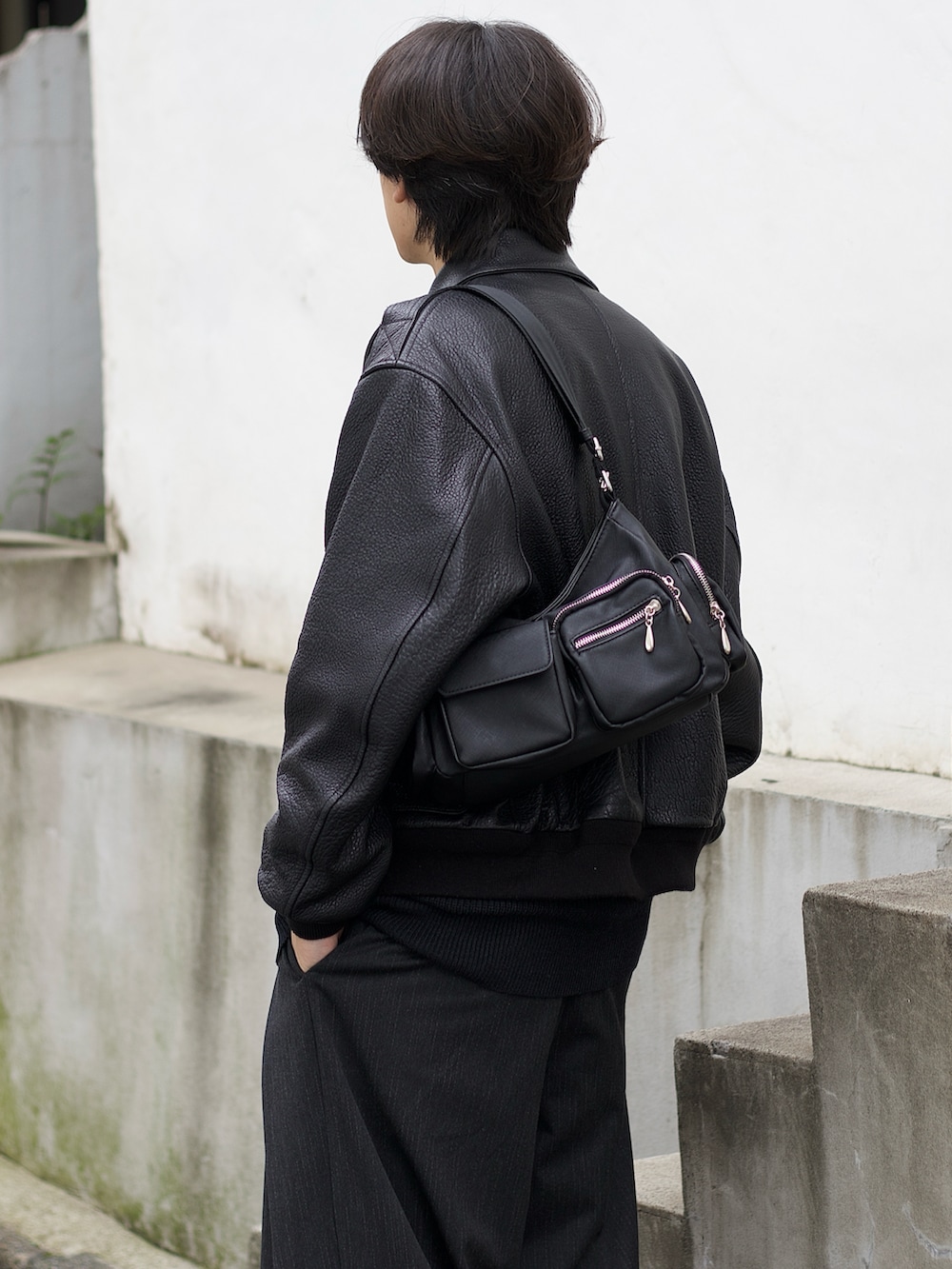 ブラック系のブルゾン、グレー系のニット/セーター、グレー系のスラックスを着用したメンズの秋コーディネートの3枚目の写真