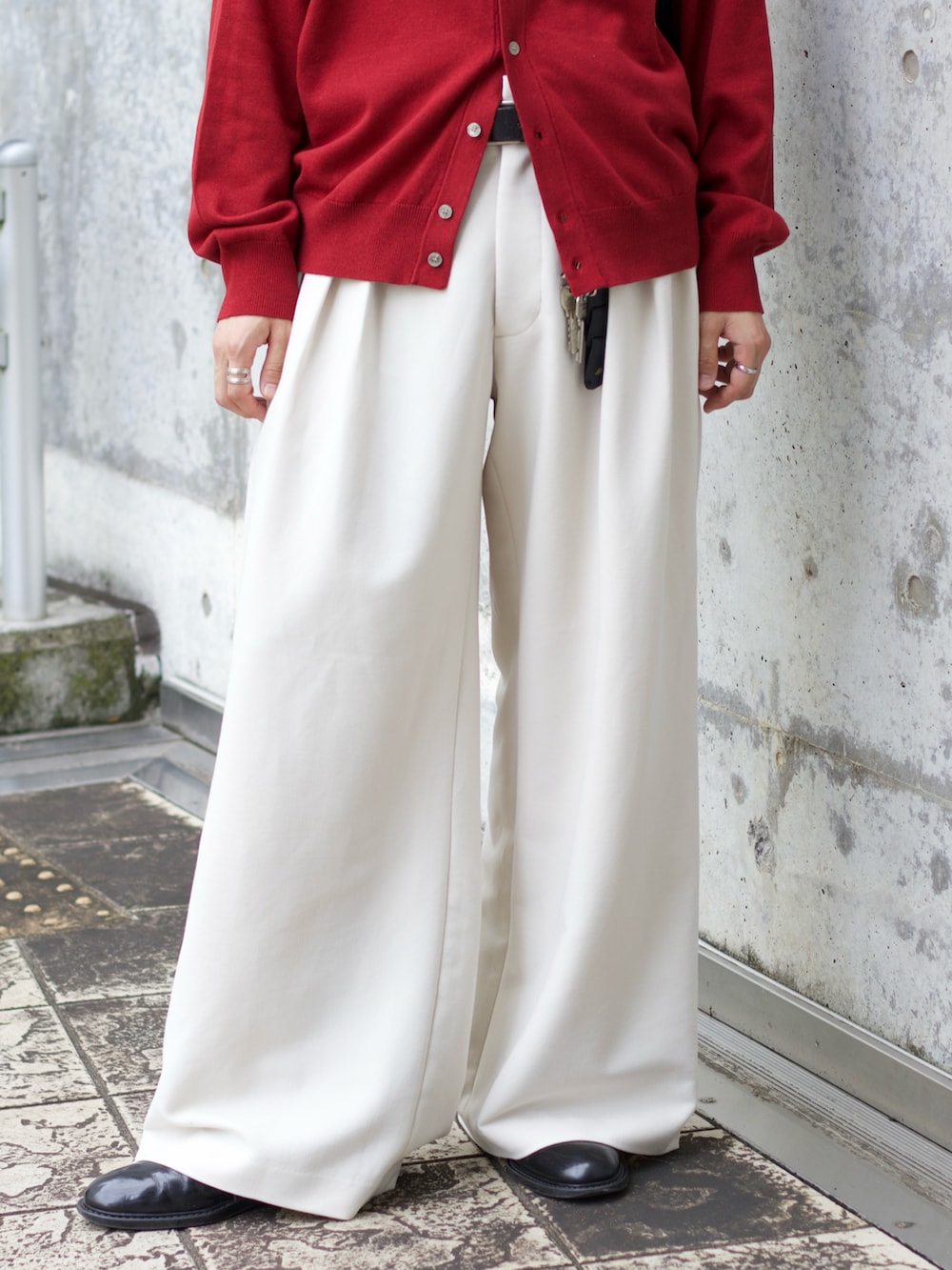 レッド系のシャツ/ブラウス、ブラック系のタンクトップ、ホワイト系のスラックスを着用したメンズの秋コーディネートの4枚目の写真